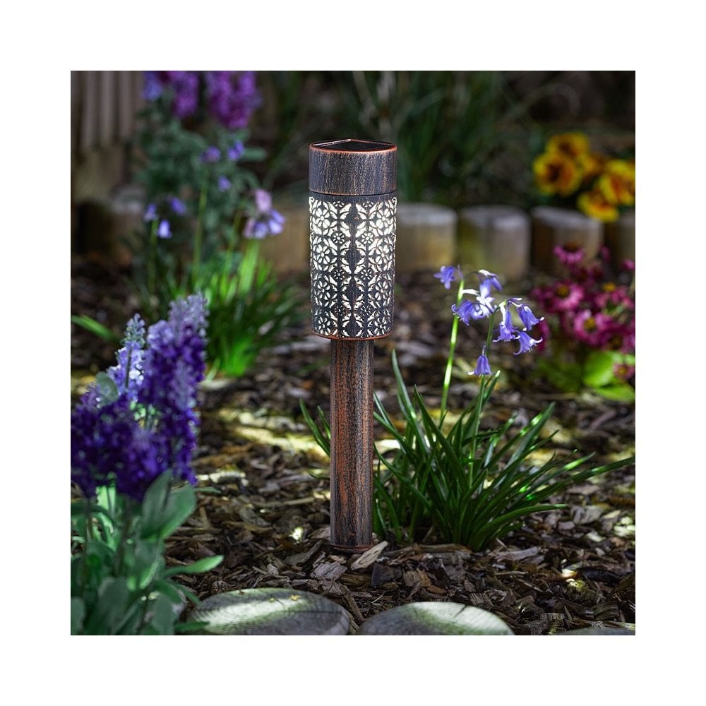 Outdoor solar spike path light in a flower bed.